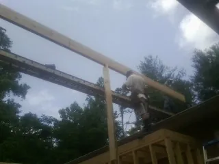 Carpenter setting a ridge beam over a new addition frame — Ice Dam Removal by Roofing Brothers in San Francisco