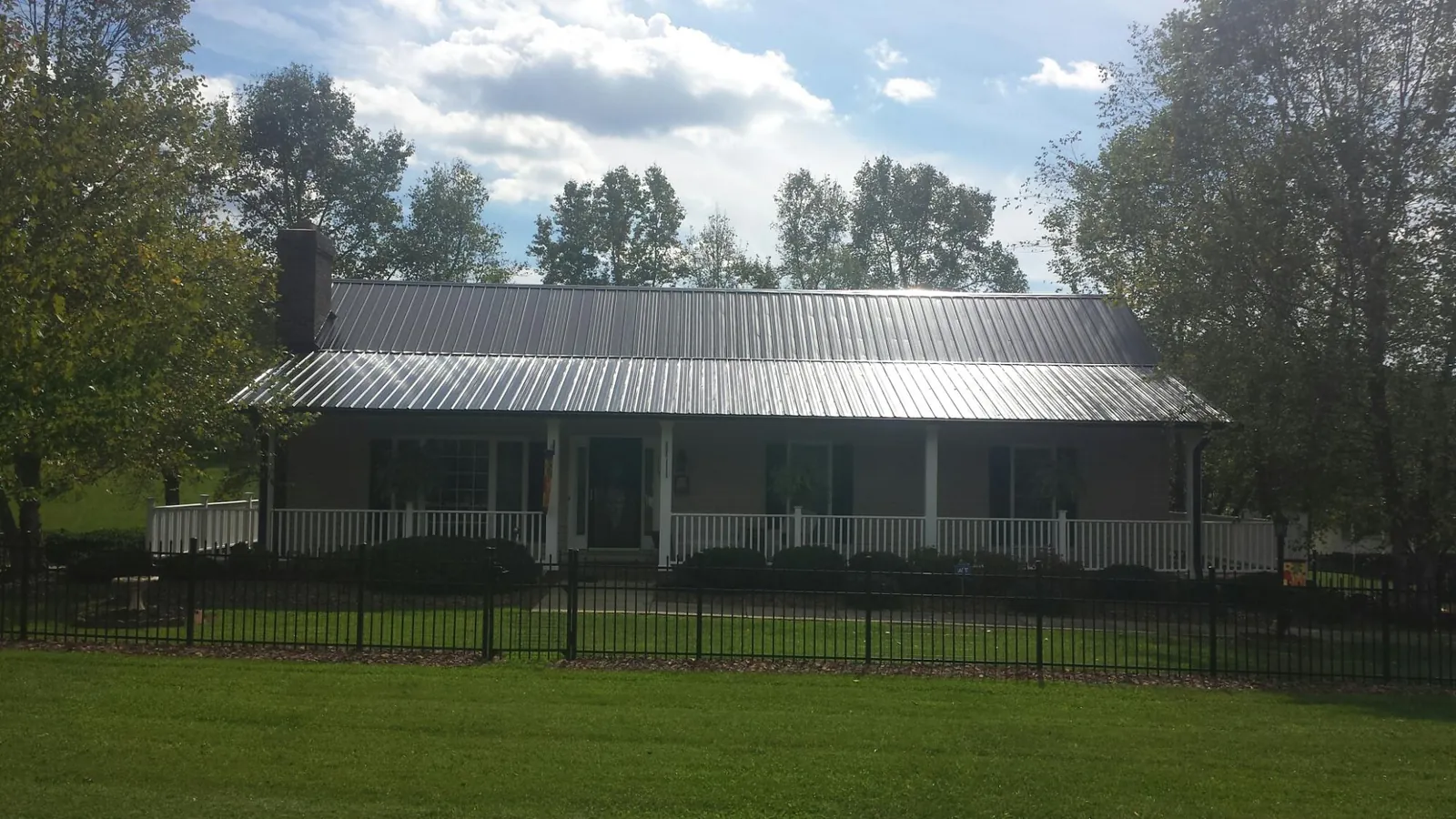 Gray metal roof on a brick ranch with a full width front porch — Gutter Guard Installation work by our crew in San Francisco